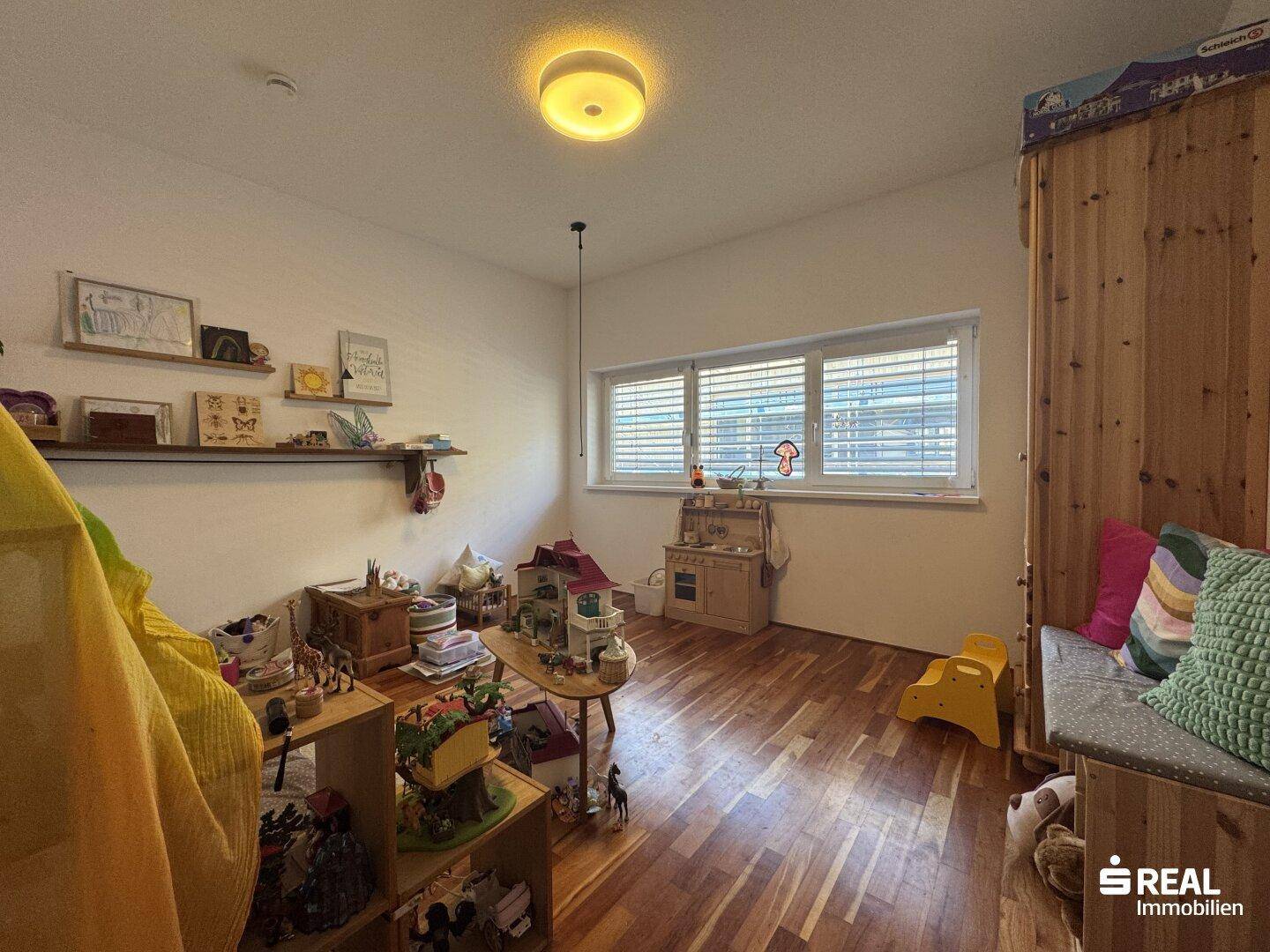 Helles Kinderzimmer mit Holzboden und viel Platz zum Spielen.
