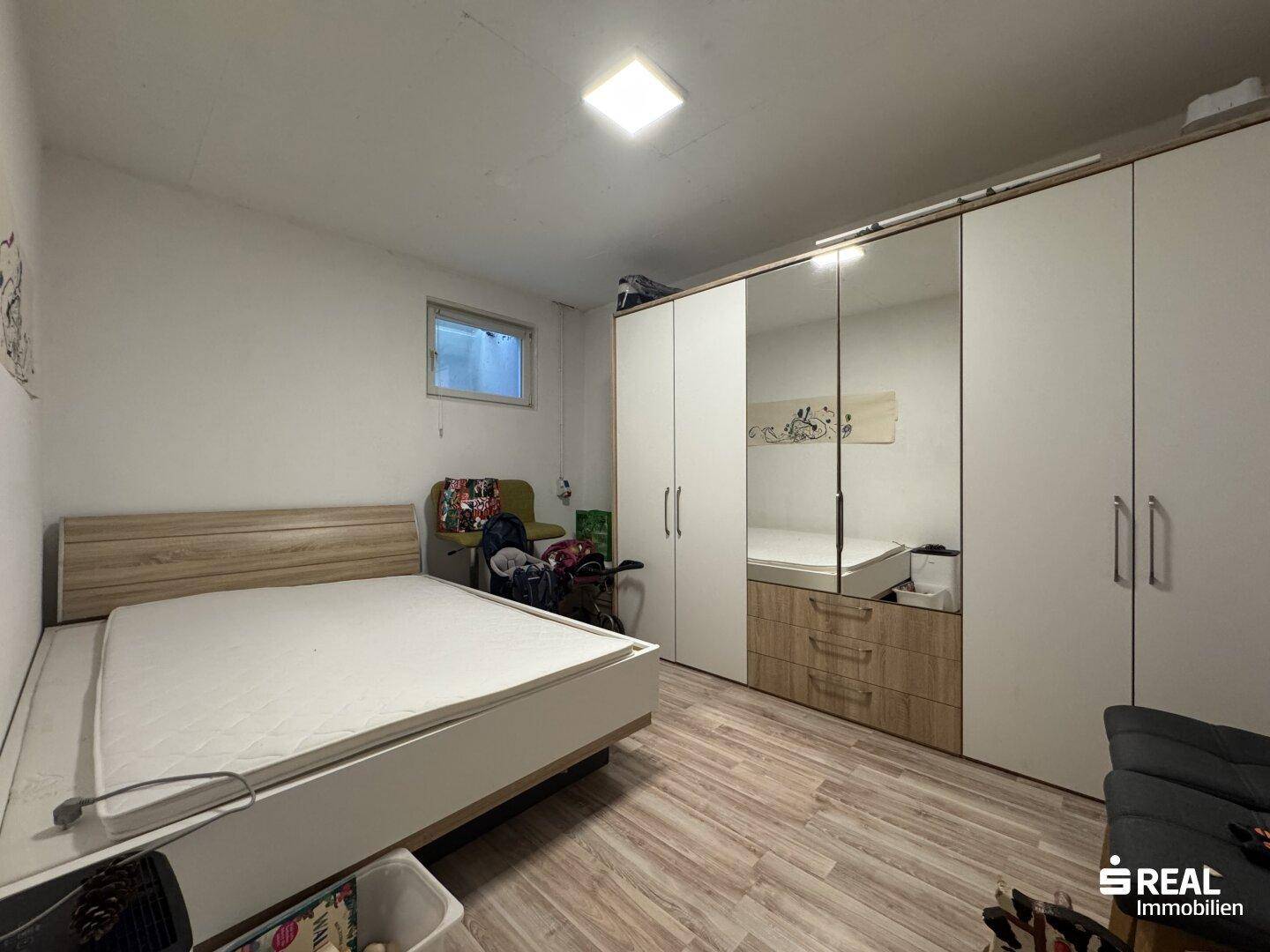 Schlafzimmer mit großem Bett, Einbauschränken und Laminatboden.