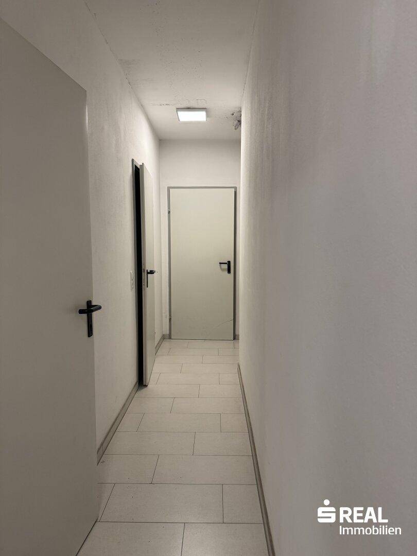 Heller Flur mit Fliesenboden und Zugang zu verschiedenen Räumen.