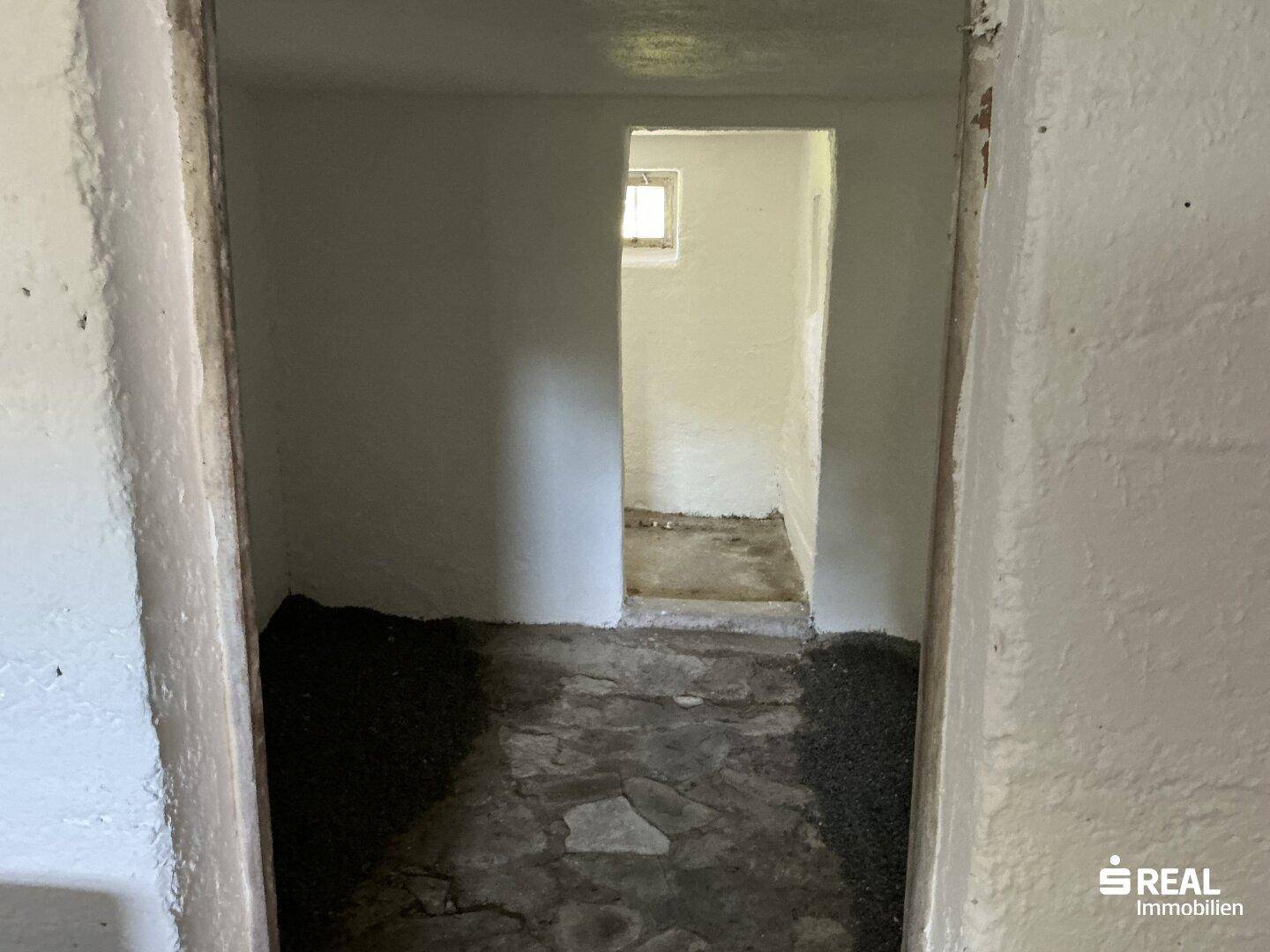 Unausgebauter Kellerraum mit Betonboden und einem kleinen Fenster, ideal als Abstellraum.