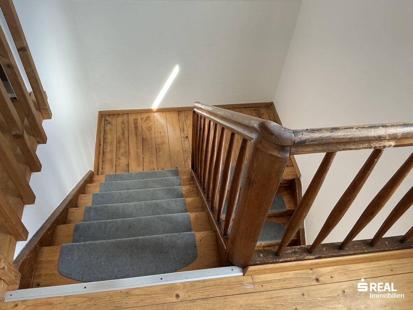 Rustikale Holztreppe mit Teppichstufen, die zu den oberen Etagen führt.