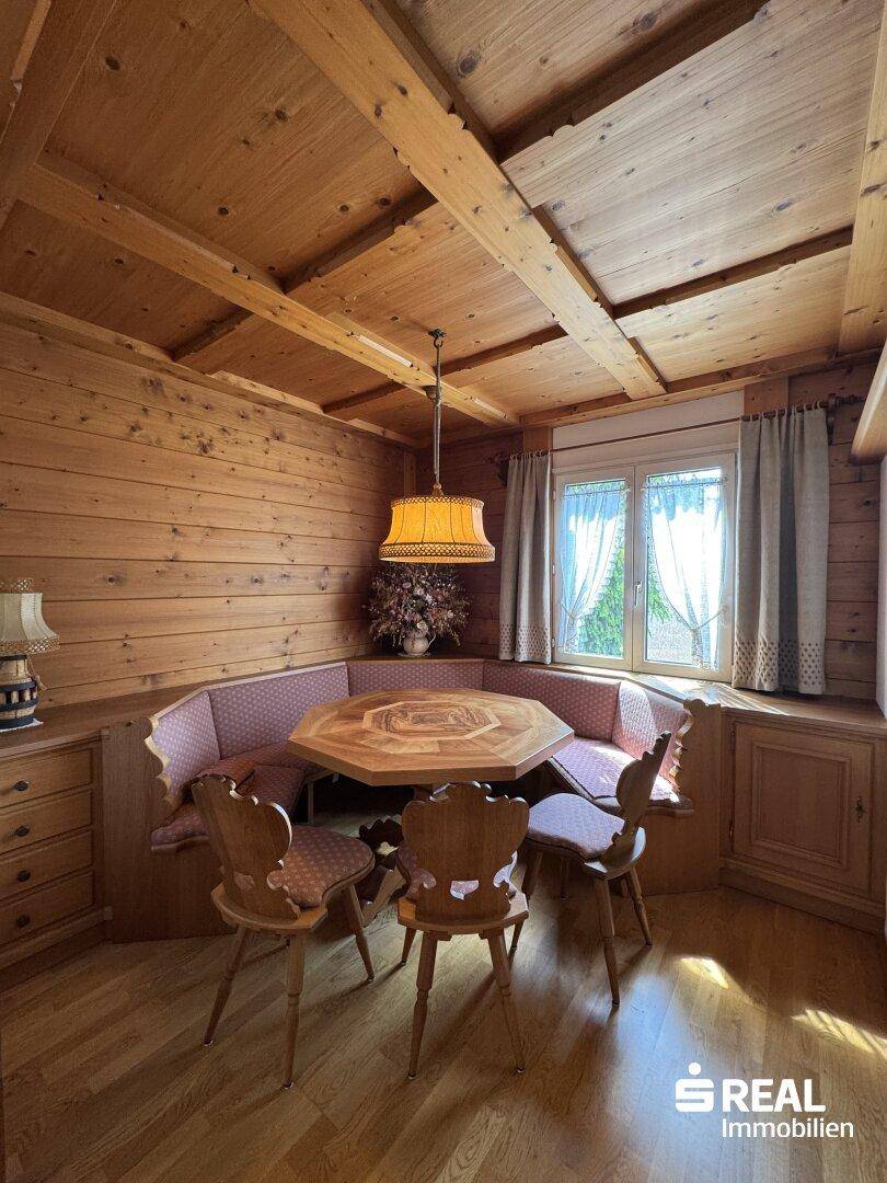 Gemütlicher Essbereich im alpinen Stil mit Holztäfelung, Eckbank und traditioneller Beleuchtung.