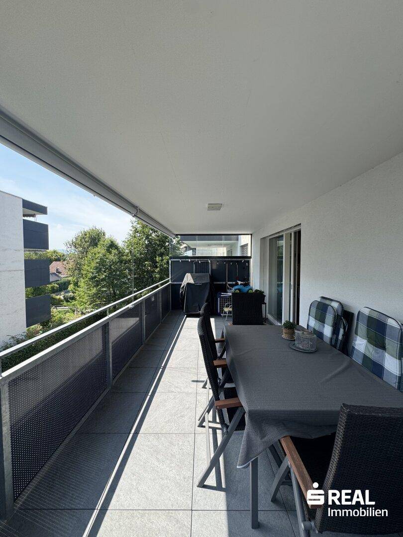Langer Balkon mit Essbereich und Blick auf die Umgebung, perfekt für entspannte Stunden.