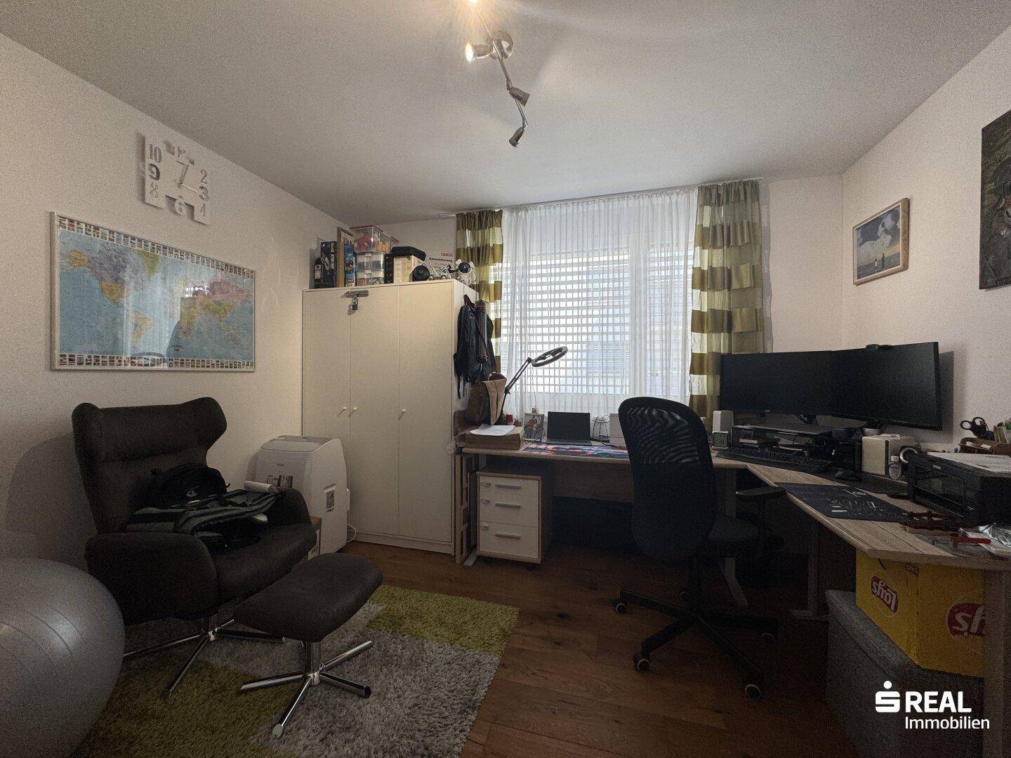 Funktionales Arbeitszimmer mit Schreibtisch, Bürostuhl und Fenster für natürliches Licht.