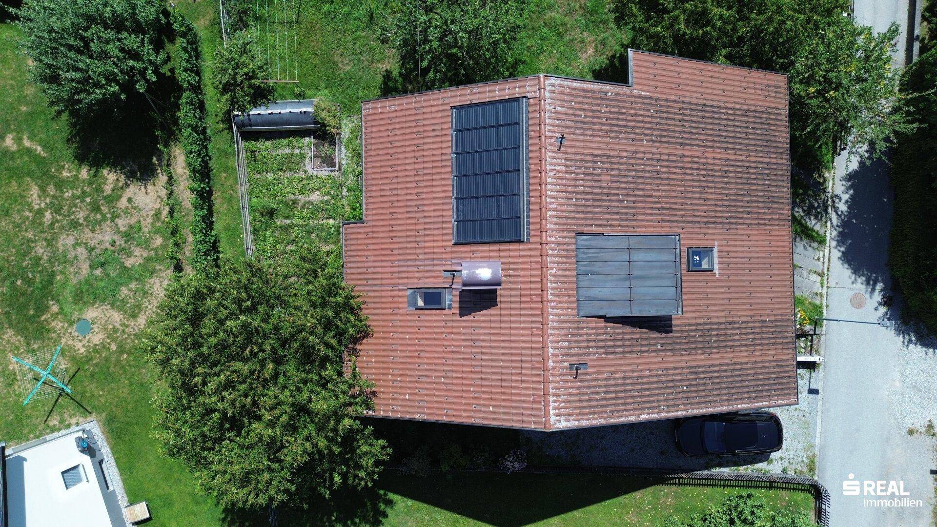 Draufsicht auf das Hausdach mit integrierten Solarmodulen und Dachfenstern.