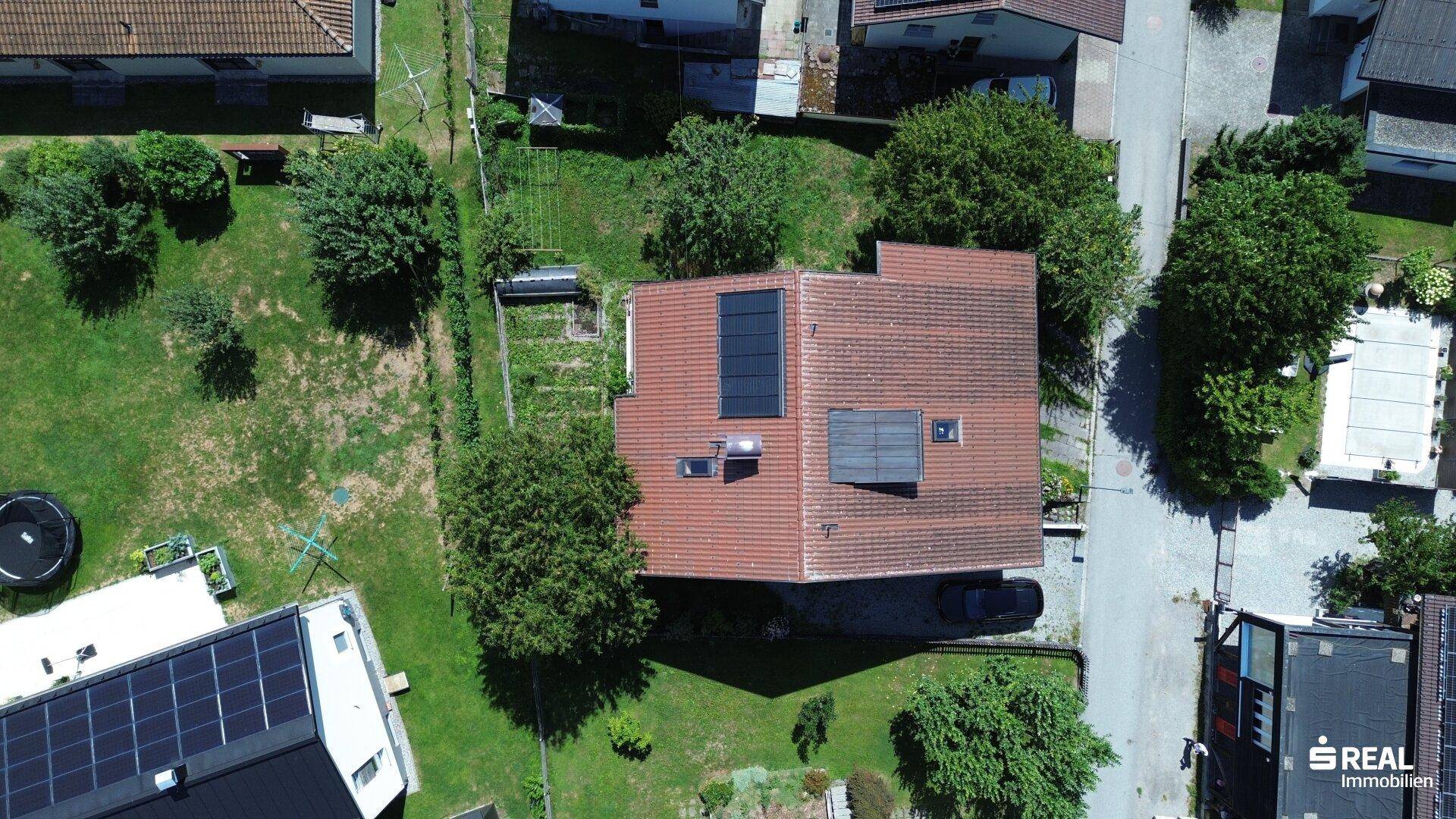 Weitläufige Luftaufnahme des Hauses mit großem Garten und angrenzender Nachbarschaft.