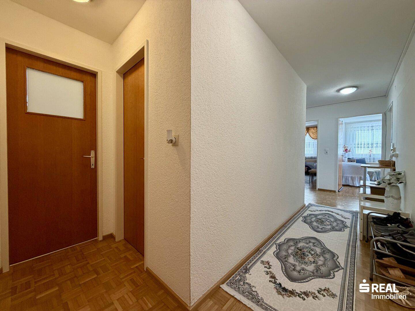 Heller Flur mit Parkettboden und Zugang zu verschiedenen Räumen der Wohnung.