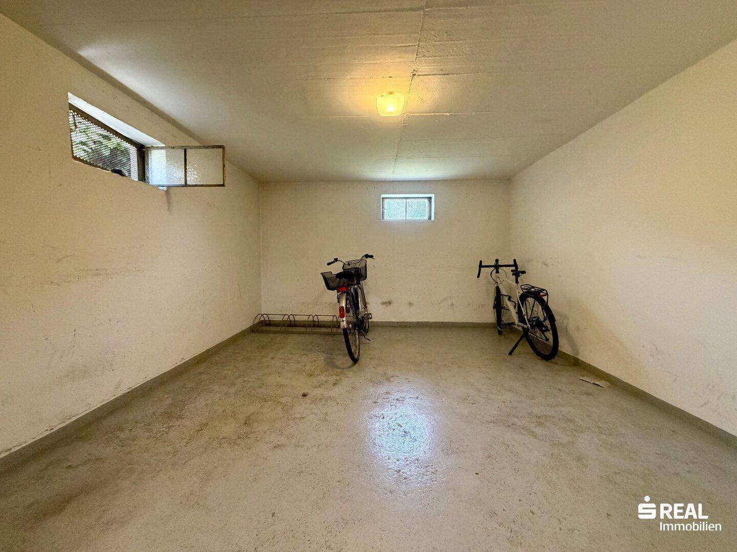 Kellerraum mit Betonboden und Fahrrädern, ideal als Abstellfläche.
