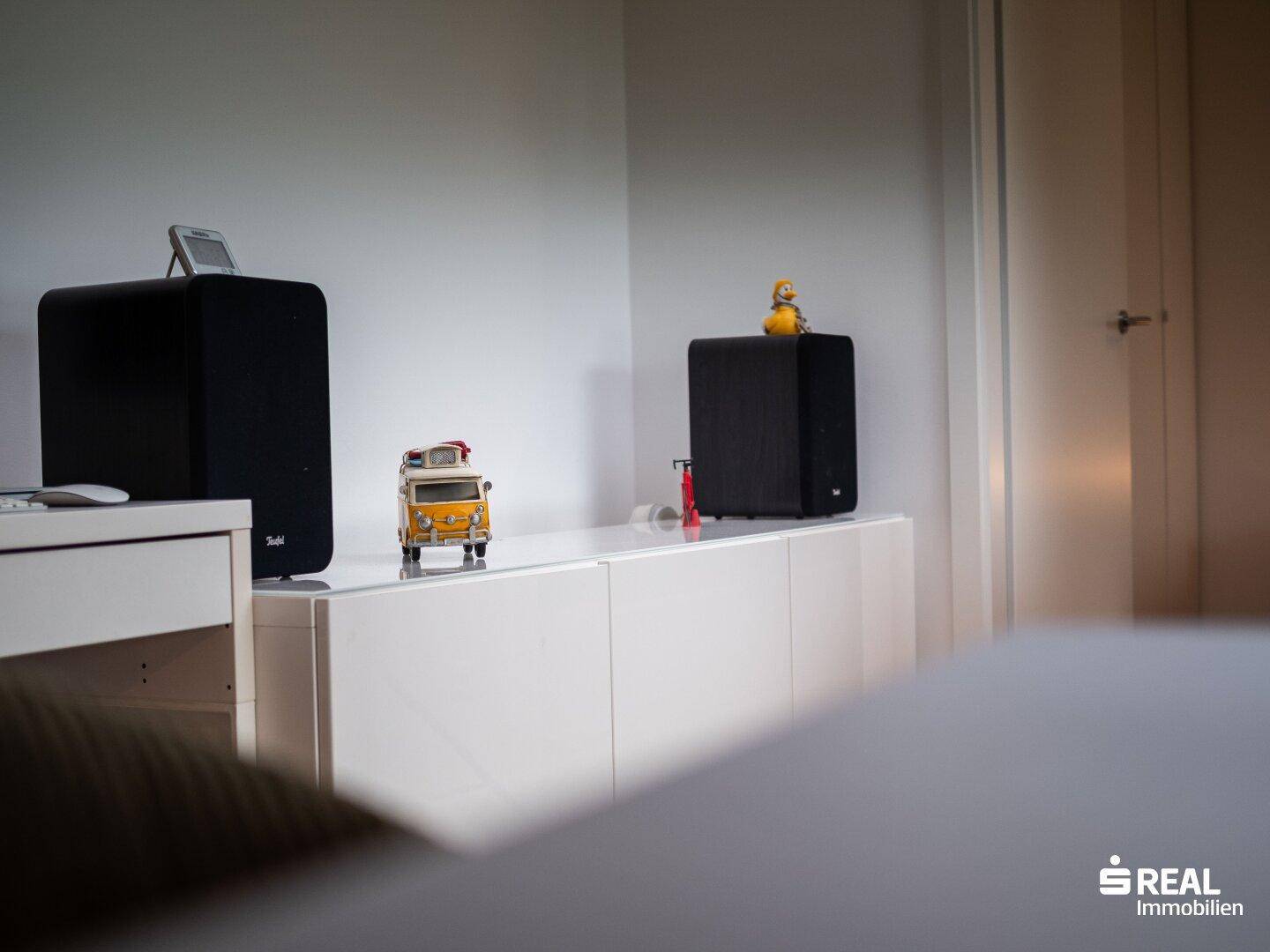 Detailansicht des Sideboards mit Lautsprechern und Dekoration im Wohnzimmer.