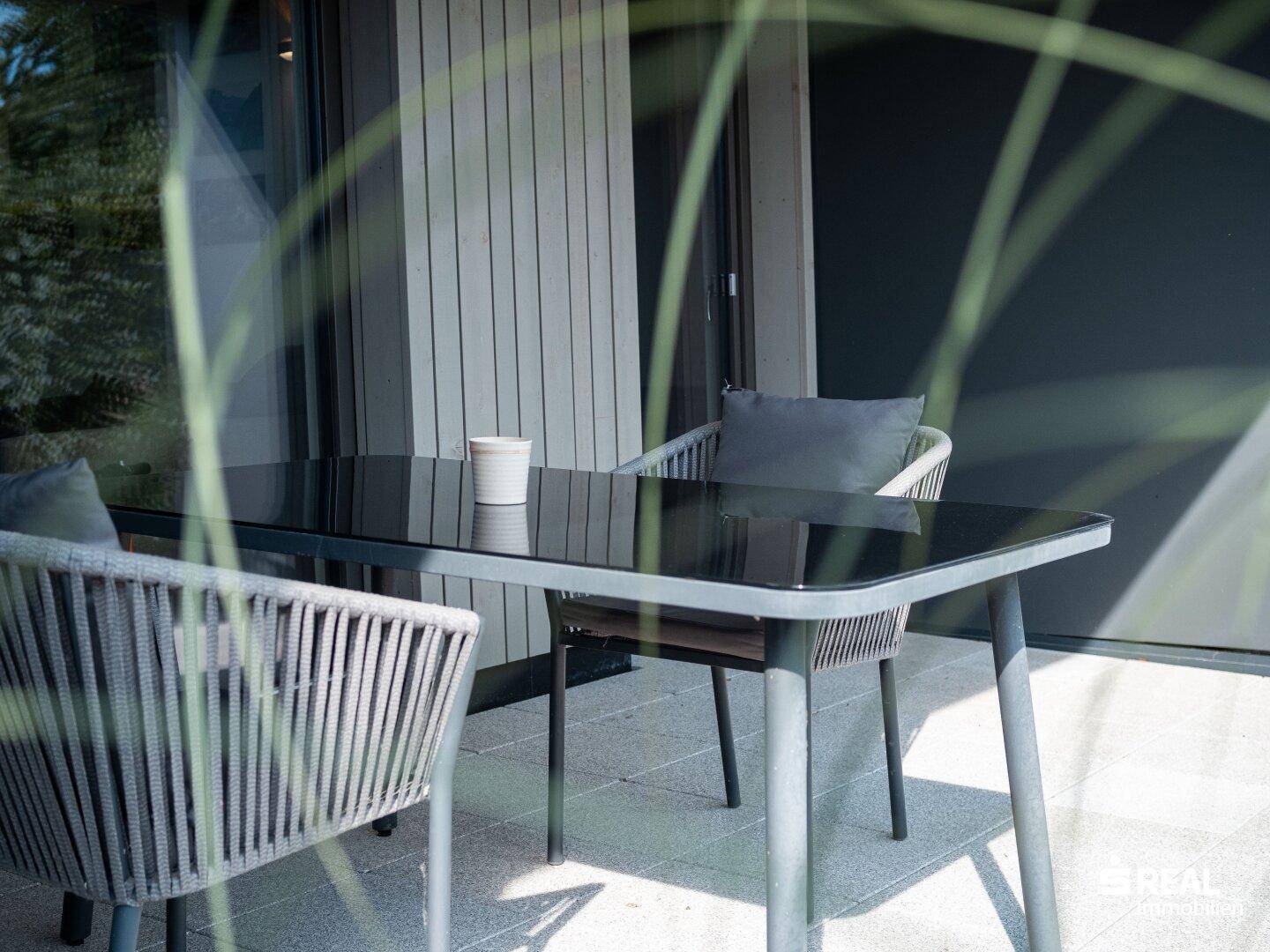 Gemütliche Terrasse mit modernen Outdoor-Möbeln und Blick ins Grüne.