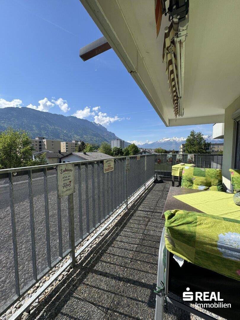 Sonniger Balkon mit Sitzgelegenheiten und weitem Blick auf die umliegende Bergwelt.
