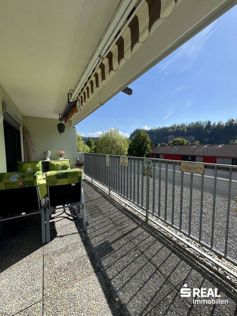 Langer Balkon mit Markise und Sitzgelegenheiten, bietet einen Blick auf die Umgebung.