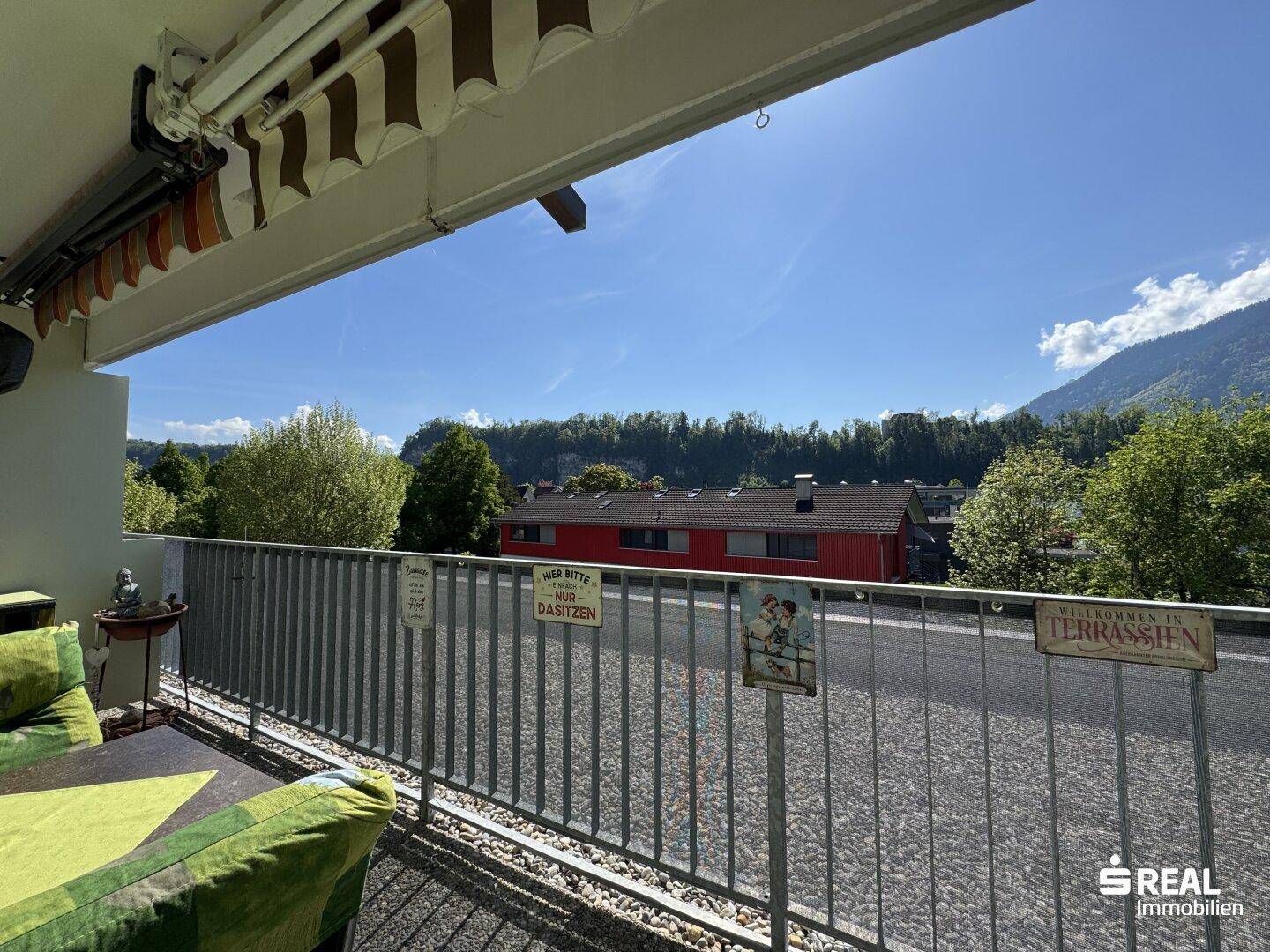 Langer Balkon mit Markise und Sitzgelegenheiten, bietet einen Blick auf die Umgebung.