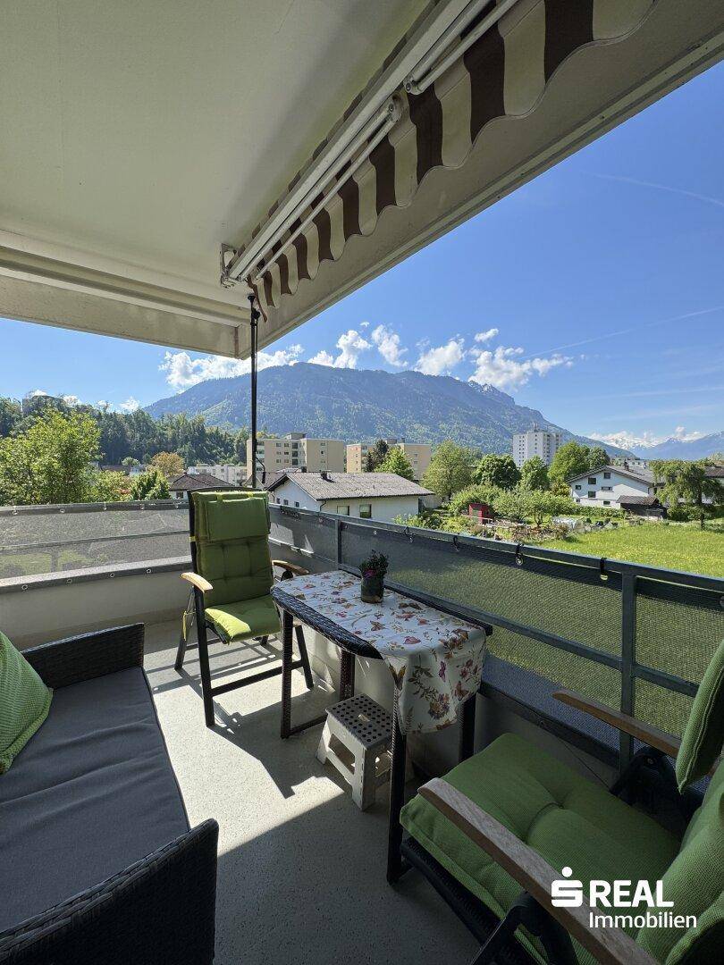 Sonniger Balkon mit Sitzgelegenheiten und weitem Blick auf die umliegende Bergwelt.