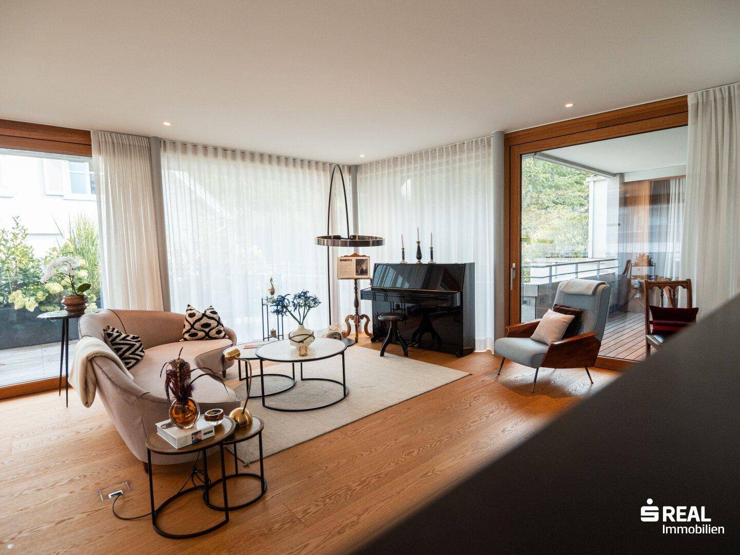 Geräumiger Wohn- und Essbereich mit Holzboden, eleganten Möbeln und viel Tageslicht.