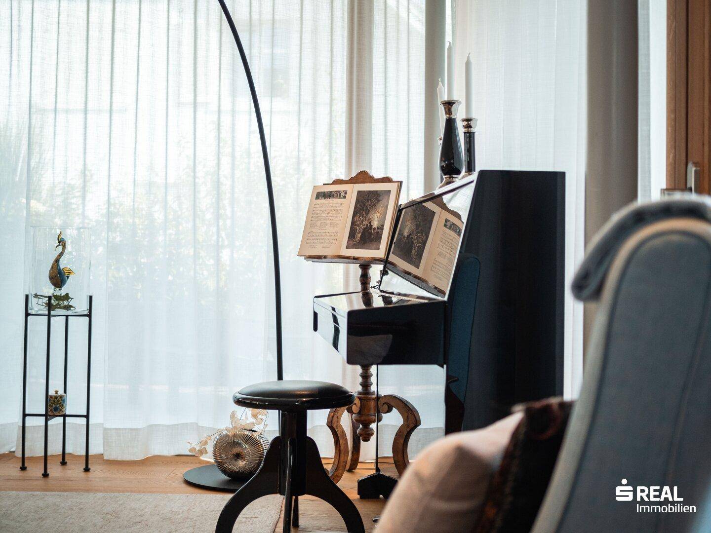 Klavier und Stehlampe im Wohnzimmer, umgeben von hellen Vorhängen und Holzboden.