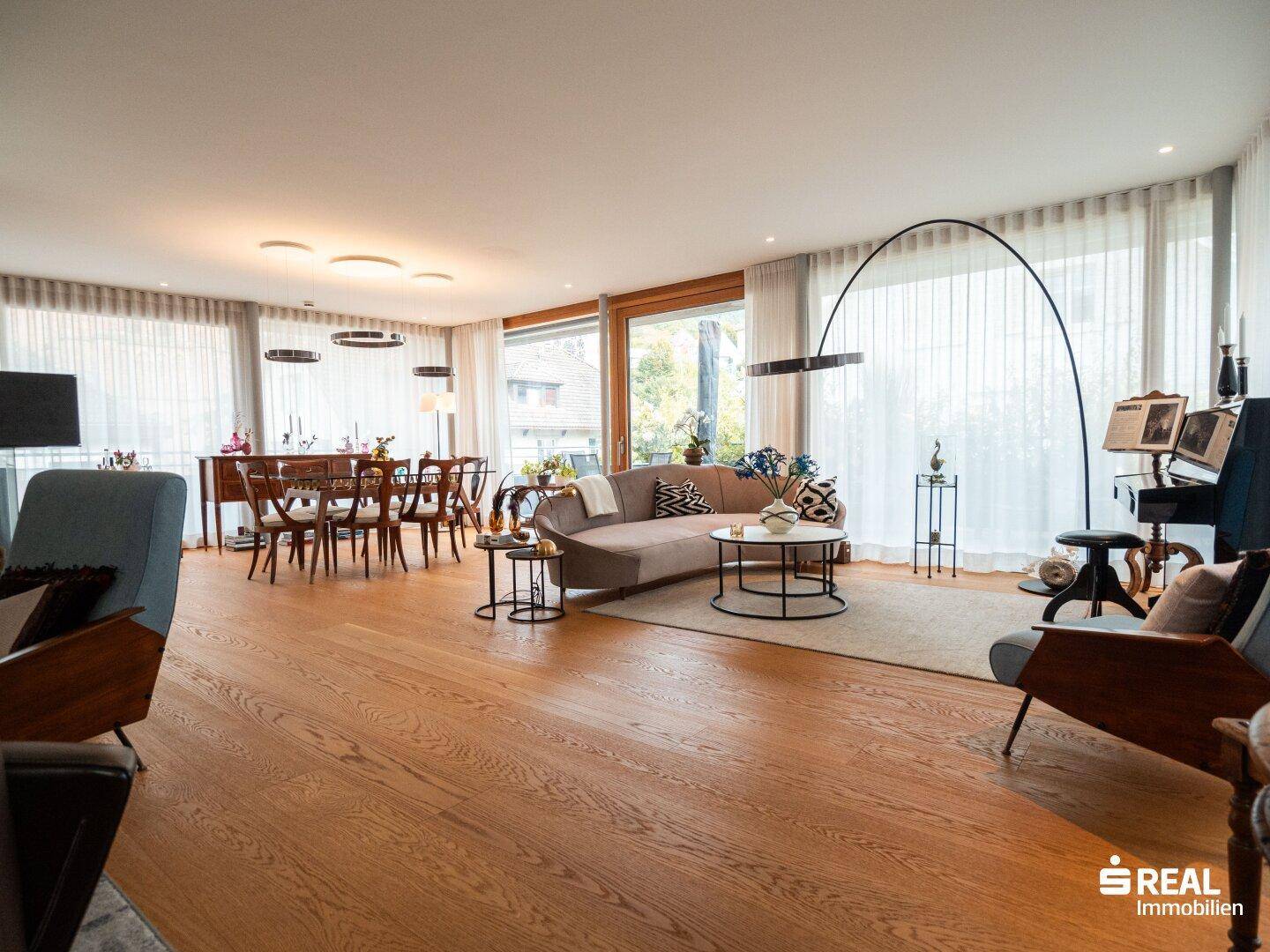 Heller und offener Wohn- und Essbereich mit Holzboden und eleganten Möbeln.
