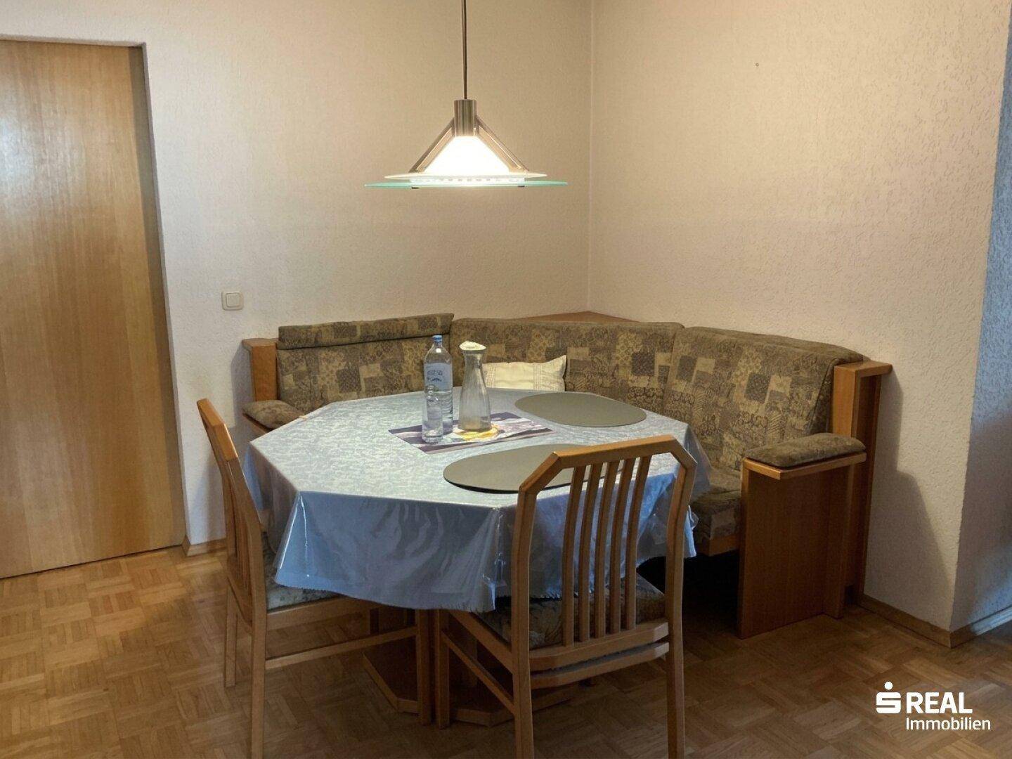 Gemütlicher Essbereich mit Eckbank, Holztisch und Pendelleuchte, ideal für Familienmahlzeiten.