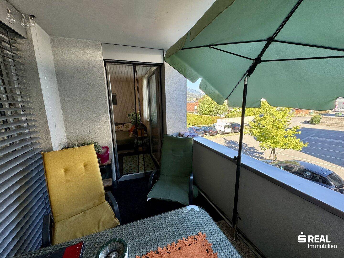 Balkon mit Sitzgelegenheiten und Blick auf die Umgebung, mit Zugang zum Innenbereich.