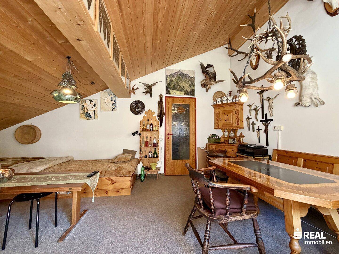 Gemütlicher Wohnbereich mit Holzbalkendecke, traditionellen Möbeln und alpiner Dekoration.