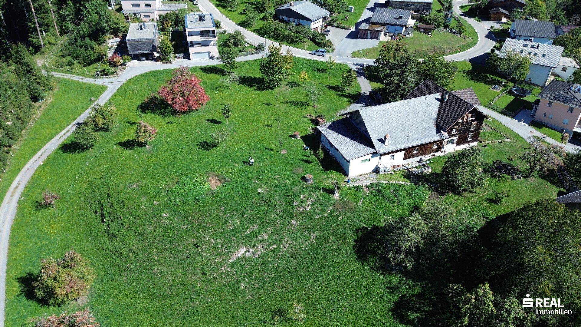 Weitläufiges Grundstück mit dem Haus und großem Garten, umgeben von Wegen und weiteren Gebäuden.