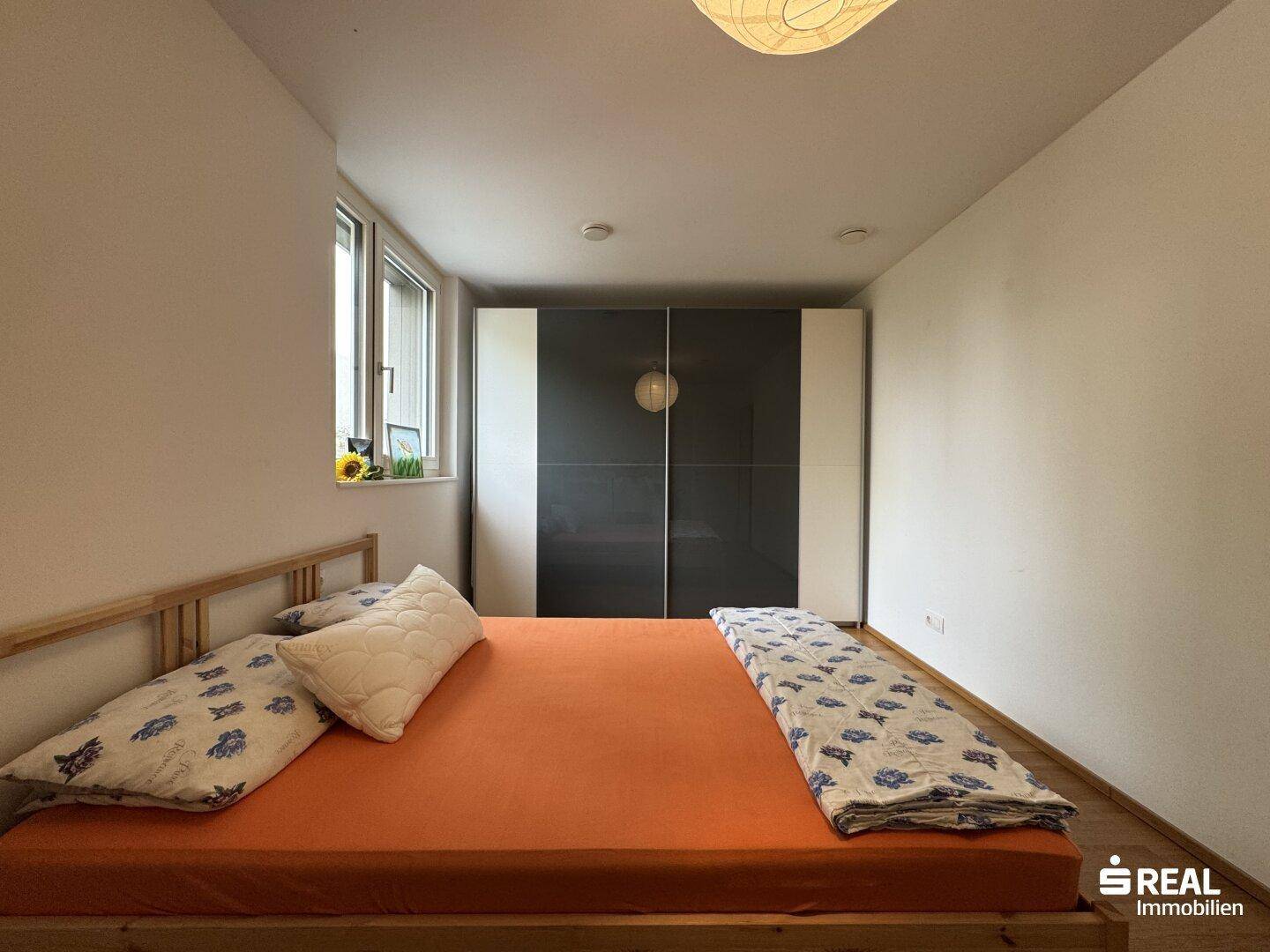 Gemütliches Schlafzimmer mit Holzboden und großem Kleiderschrank, bietet viel Platz.