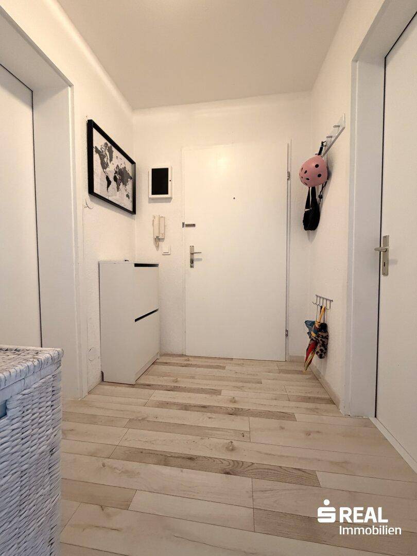 Eingangsbereich mit hellem Holzboden und Garderobe, freundlich und einladend.