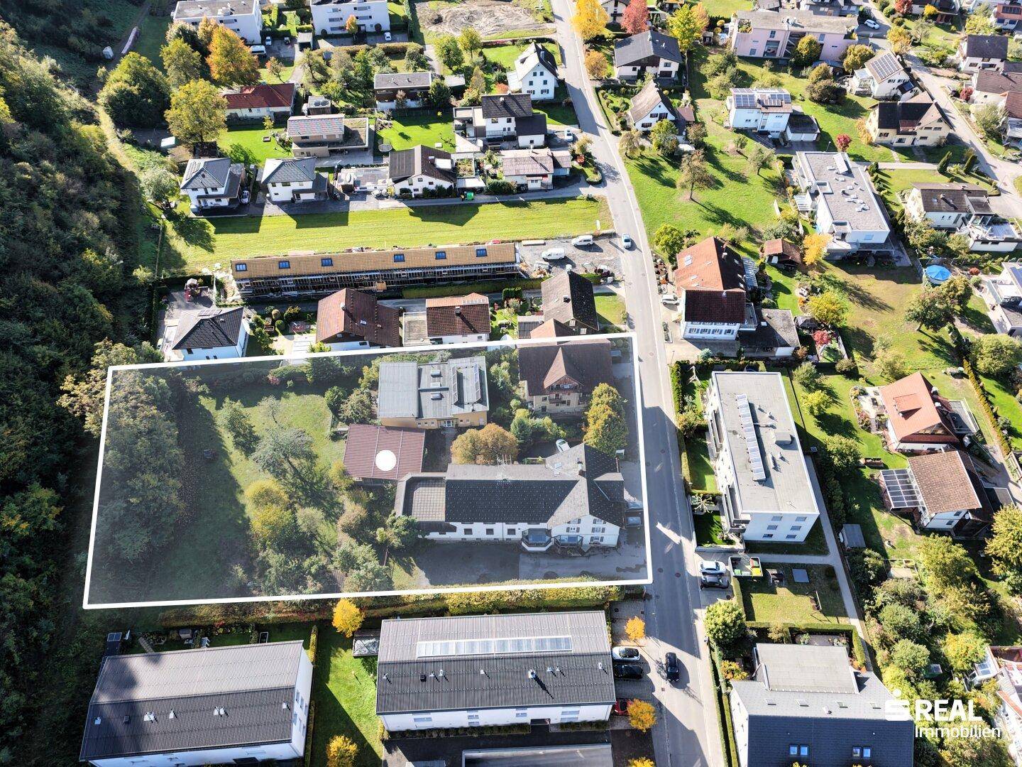 Weitläufige Luftansicht des Grundstücks in einer Wohngegend mit viel Grün.