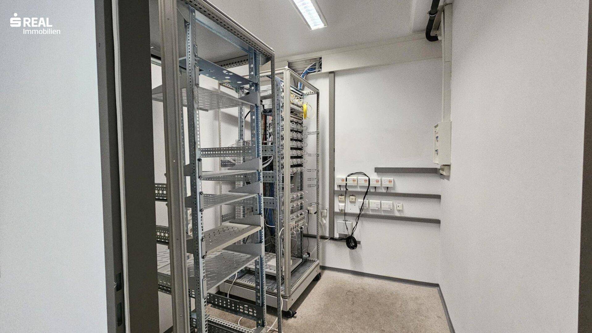 Serverraum mit mehreren Racks und Verkabelung, bereit für IT-Infrastruktur.