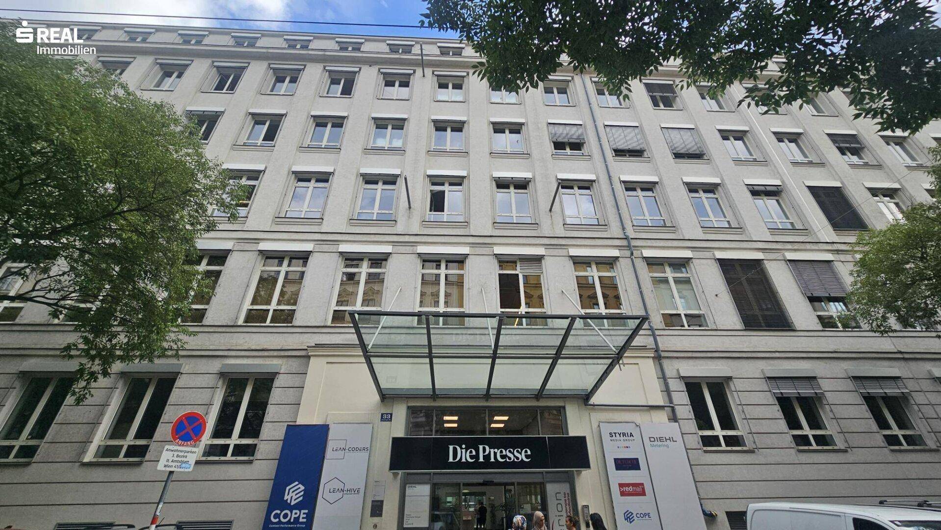 Klassische Fassade eines Bürogebäudes mit vielen Fenstern und einem modernen Eingangsbereich.