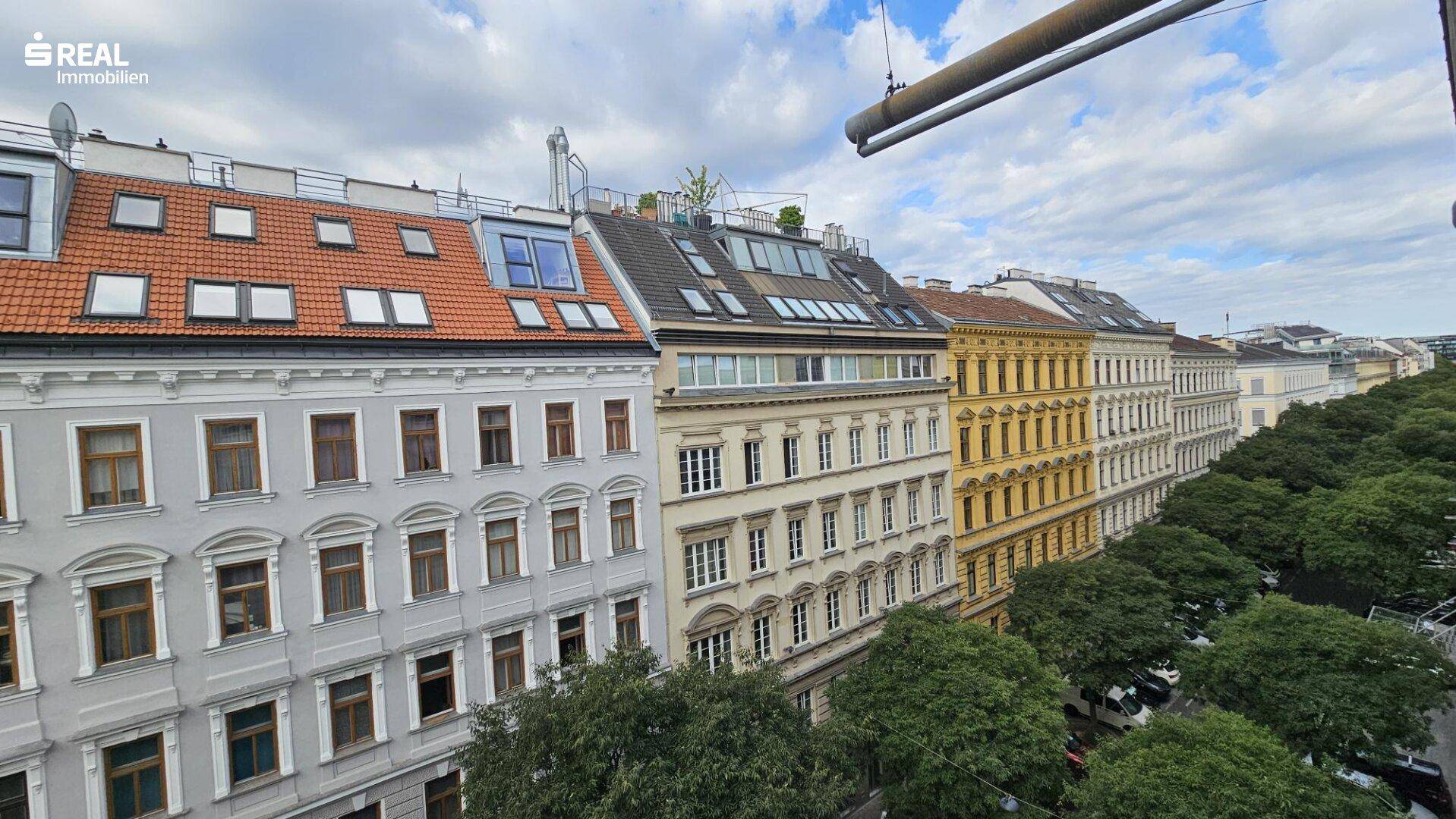 Reihe von historischen Gebäuden mit unterschiedlichen Dächern und vielen Fenstern in einer Stadtansicht.