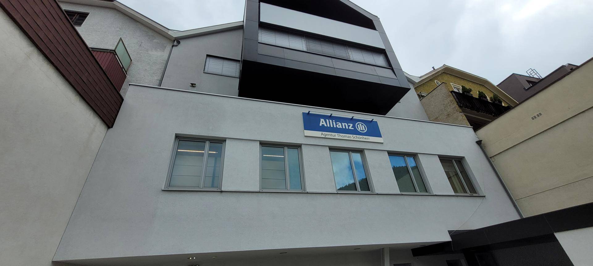 Moderne Gebäudefassade mit großen Fenstern und einem Allianz-Schild.