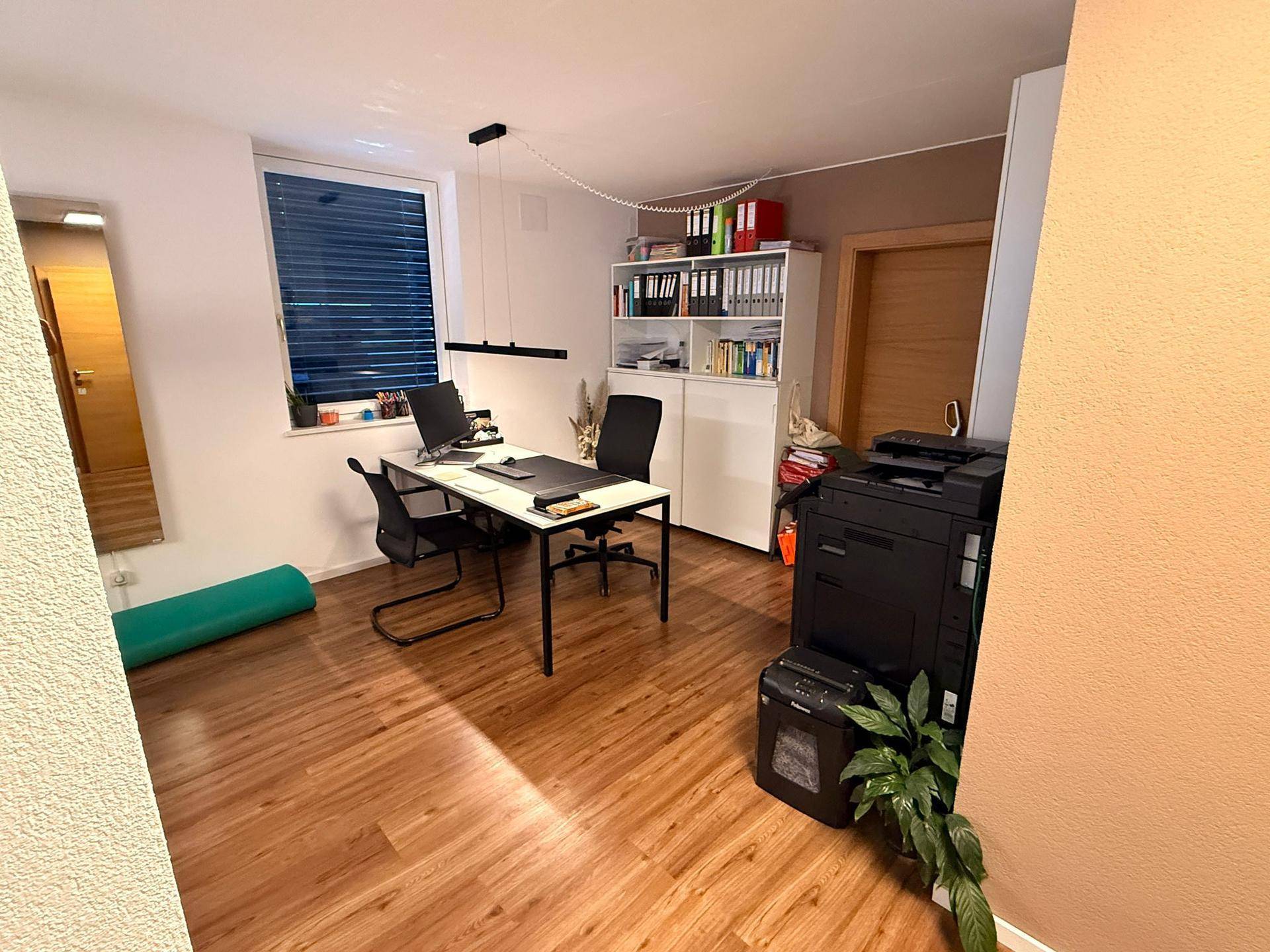 Geräumiges Büro mit Holzfußboden, Schreibtisch und Büromöbeln, ideal für produktives Arbeiten.