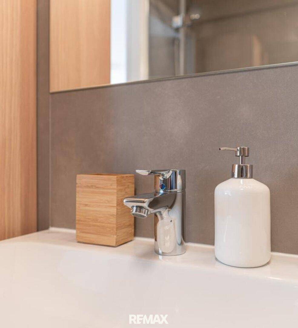 Nahaufnahme des modernen Waschbeckens mit Armatur und Seifenspender im Badezimmer.