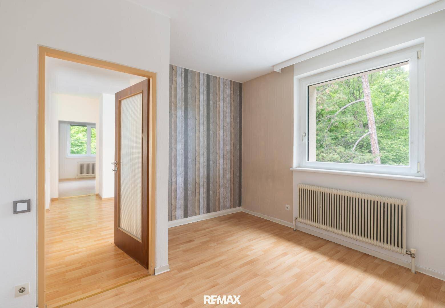 Unmöbliertes Zimmer mit Parkettboden und einer Akzentwand, ideal als Schlaf- oder Arbeitszimmer.