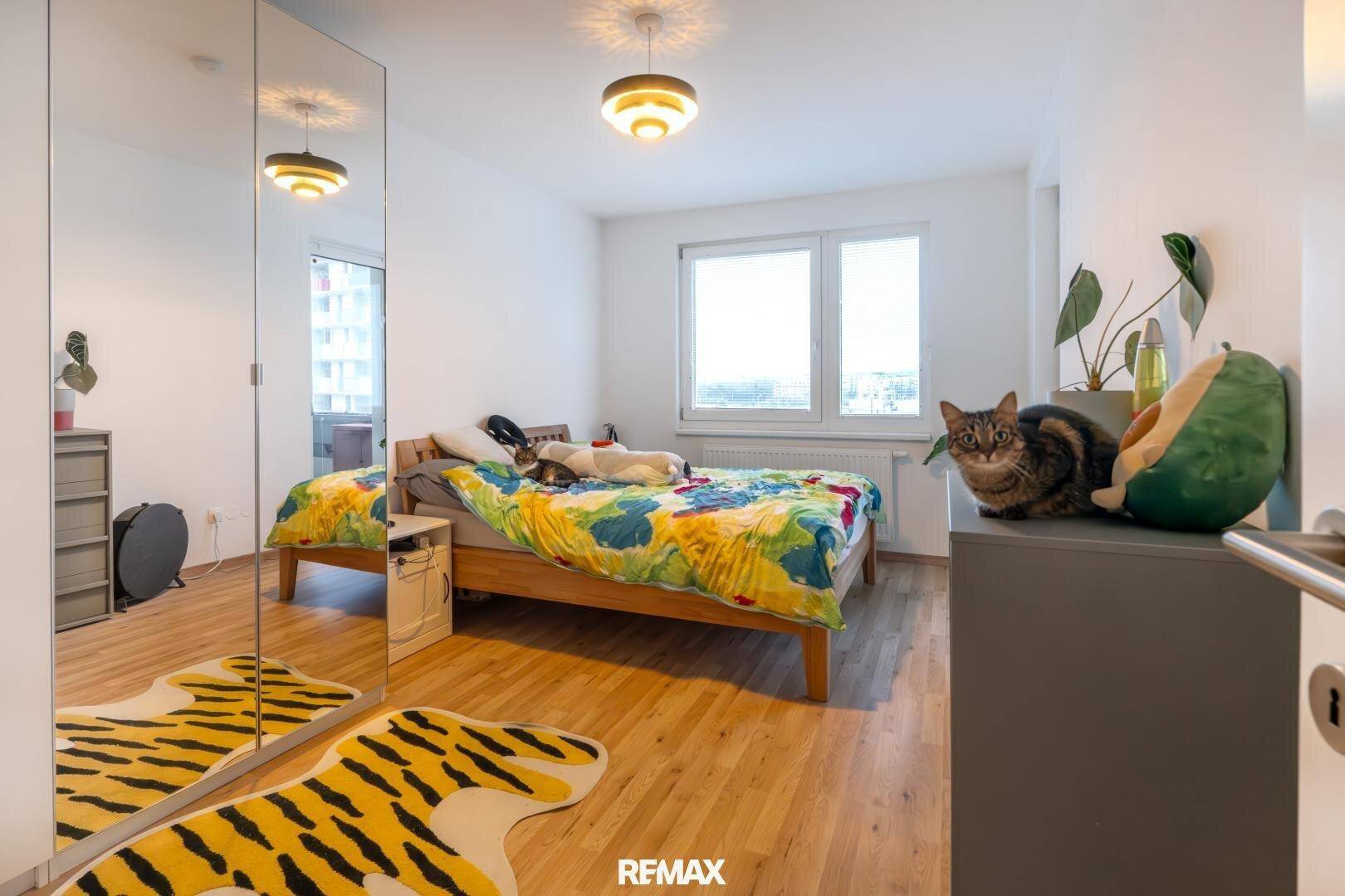 Gemütliches Schlafzimmer mit Holzbett, Spiegelschrank und Blick auf die Stadt.