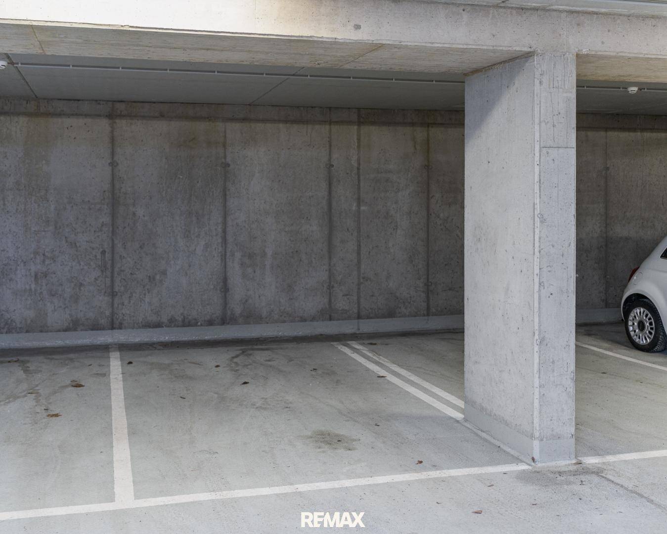 Tiefgarage mit Betonwänden und markierten Parkplätzen.