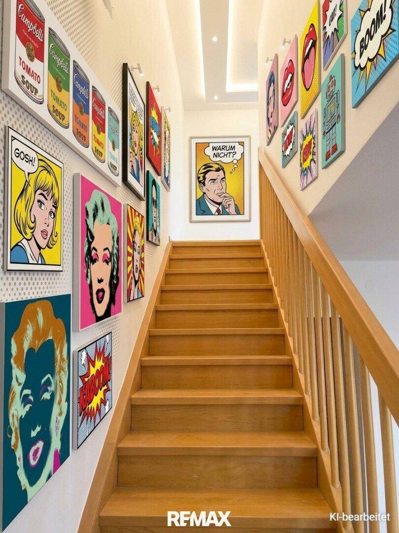 Heller Treppenaufgang mit Holzstufen und farbenfroher Pop-Art-Dekoration an den Wänden.