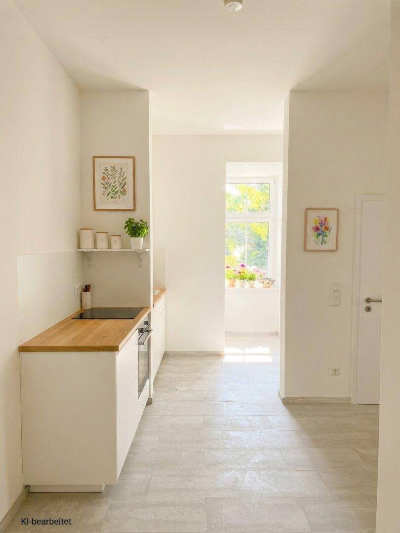 Helle Küchenzeile mit Holz-Arbeitsplatte, weißen Schränken und einem Fenster mit Blick ins Grüne.