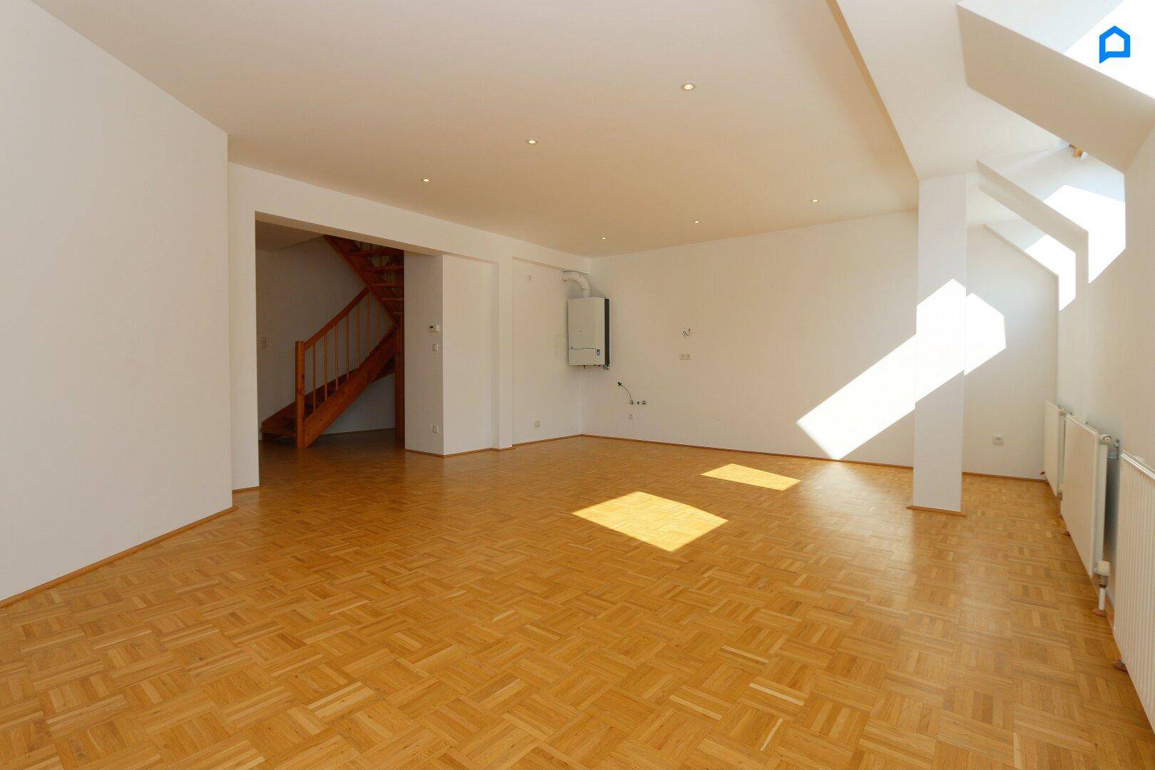 Geräumiger, heller Wohnbereich mit Parkettboden, Dachfenstern und Heizkörpern, bereit zur individuellen Gestaltung.