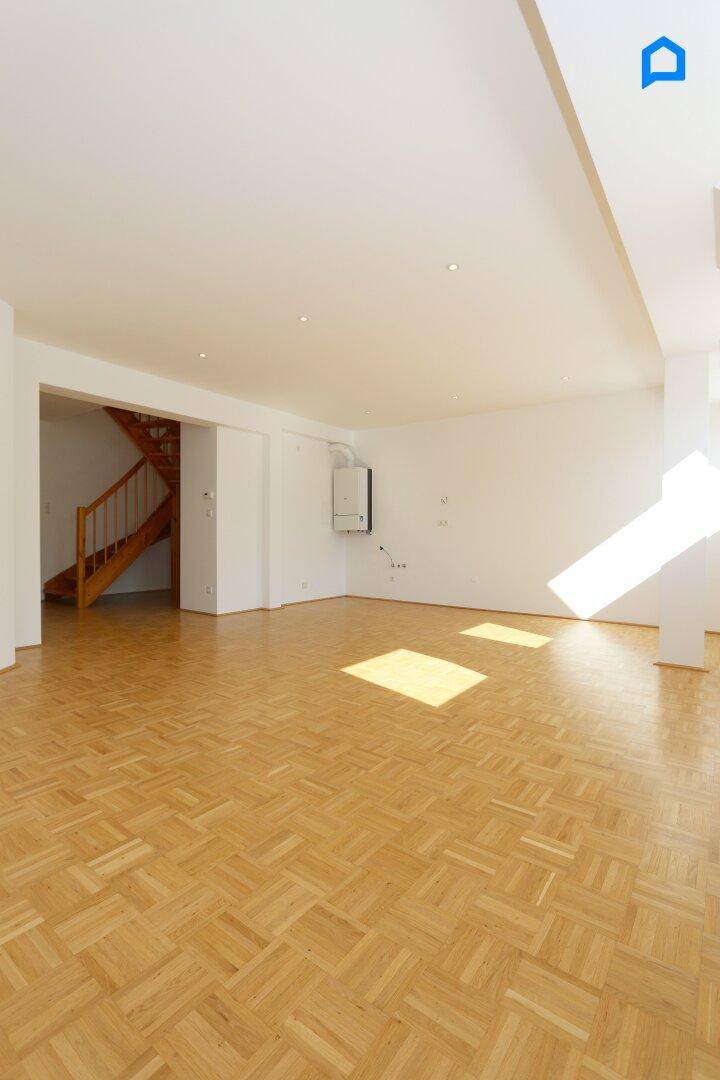 Geräumiger Wohnbereich mit Parkettboden, Dachfenstern und Heizkörpern, ideal für individuelle Einrichtungsideen.