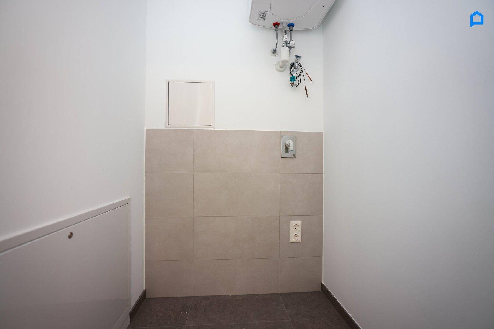 Praktischer Hauswirtschaftsraum mit Anschlüssen für Waschmaschine und Boiler, funktional gestaltet.
