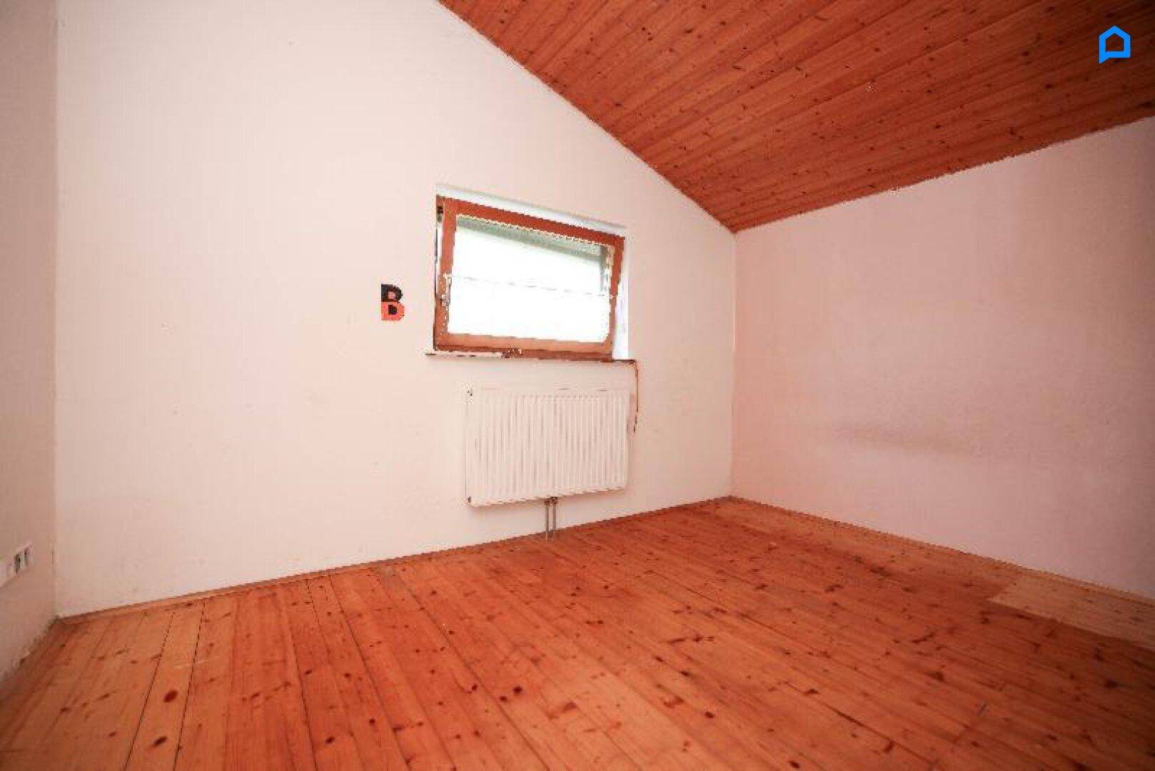 Helles Schlafzimmer mit Holzboden, Holzdecke und Dachschräge, ideal für ein gemütliches Ambiente.