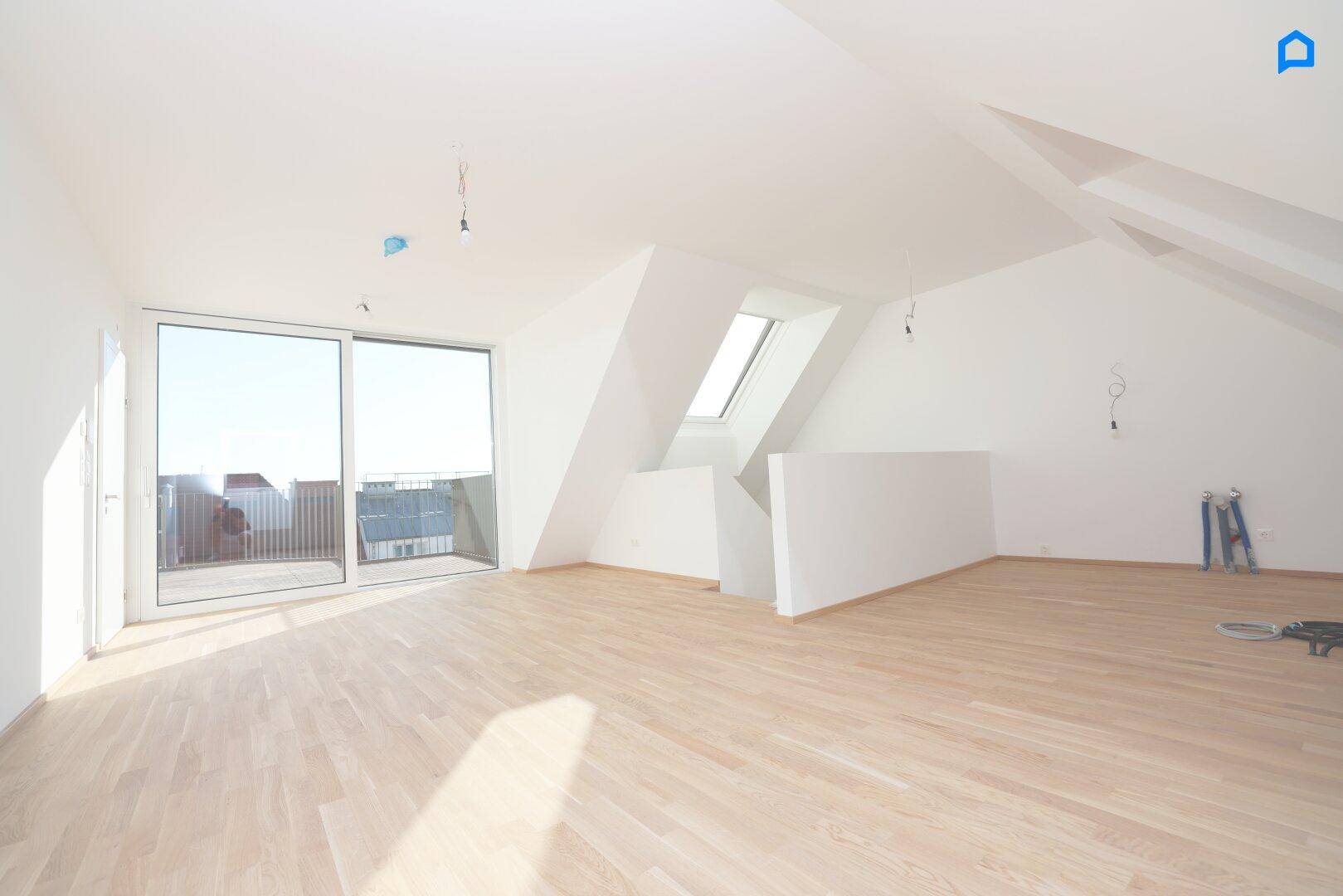 Helles Dachgeschosszimmer mit Holzboden, großen Schiebetüren und Dachfenstern, bietet viel natürliches Licht.
