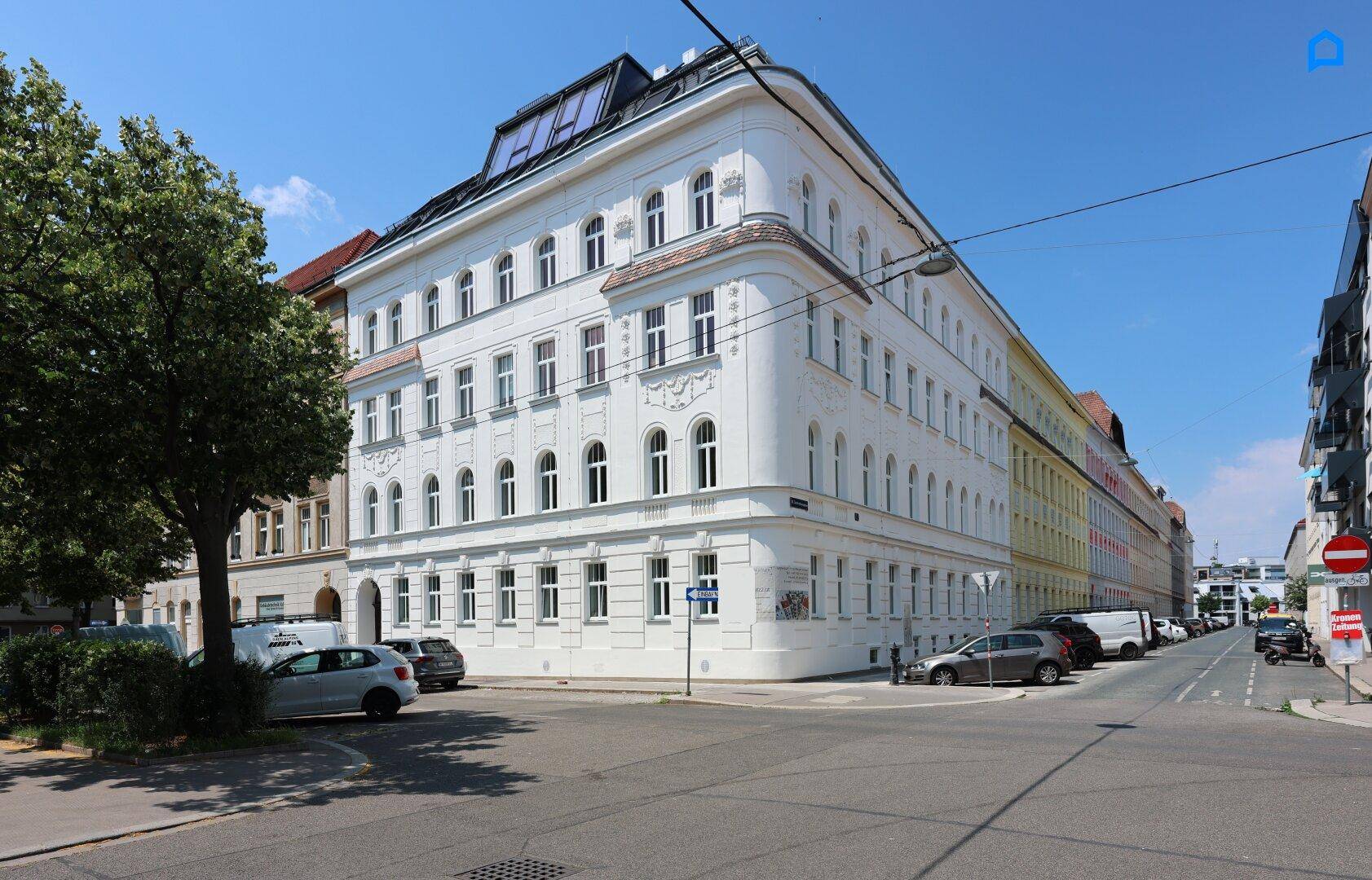 Das Eckgebäude präsentiert sich als sanierter Altbau mit moderner Dachaufstockung in urbaner Umgebung.