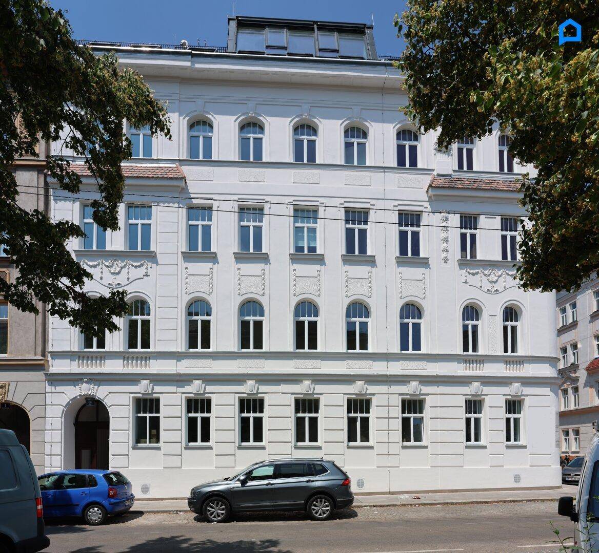 Detailansicht der frisch sanierten Fassade eines Mehrfamilienhauses mit großen Fenstern.