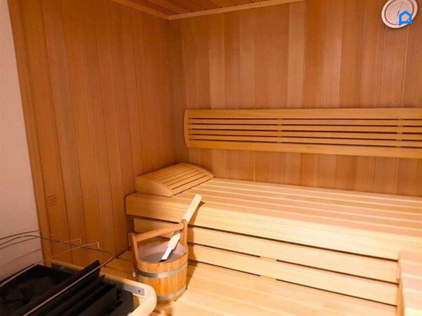 Gemütliche Holzsauna mit Bänken und traditionellem Saunaofen für Entspannung.