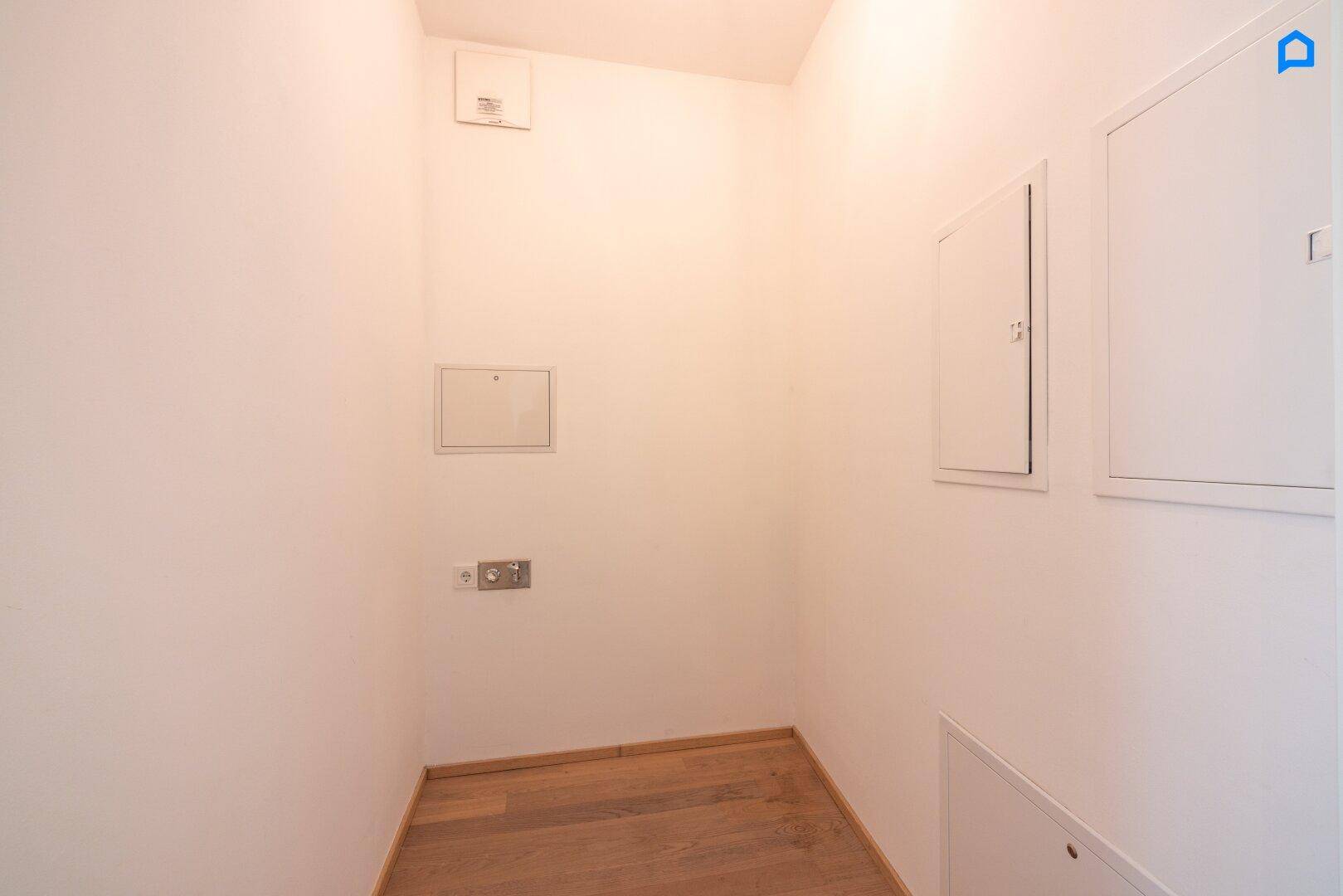 Kleiner Abstellraum mit Anschlüssen und Zugangsklappen, ideal für Lagerung.
