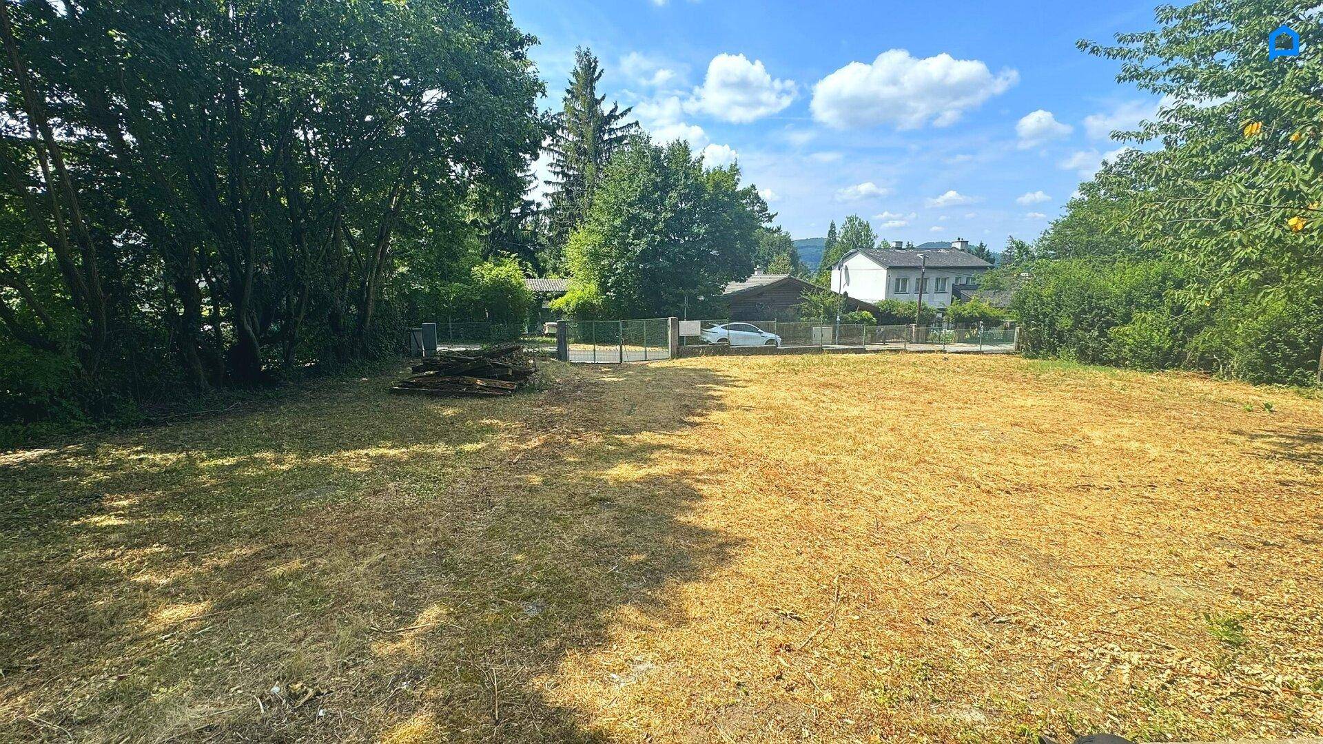 Weitläufiges Gartengrundstück mit Blick auf die Umgebung und entfernte Häuser.