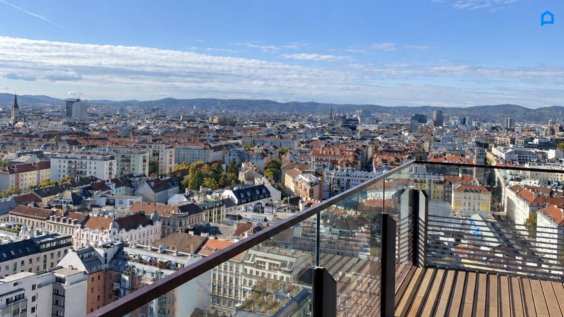 Atemberaubender Panoramablick über die Dächer der Stadt und die umliegende Landschaft von einer Dachterrasse.
